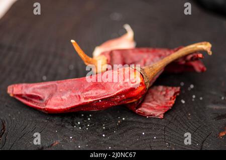 Peperoncini caldi su una tavola nera rustica in legno in un mercato di Street food, da vicino Foto Stock