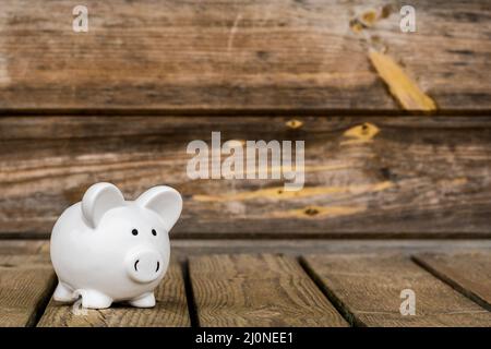 Piggy banca sul vecchio sfondo di legno Foto Stock