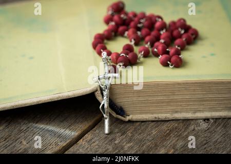 Rosario cattolico sul libro antico aperto Foto Stock