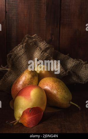Pere mature su sfondo di legno scuro in stile rustico Foto Stock