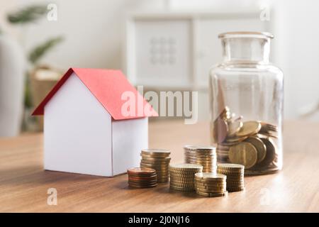 Banco in miniatura con pile di monete vaso accanto . Alta qualità e risoluzione bellissimo concetto di foto Foto Stock