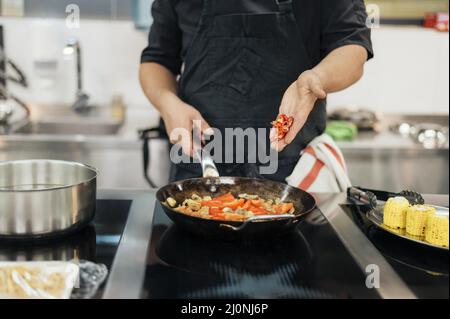 Chef maschile che aggiunge il peperoncino. Alta qualità e risoluzione bellissimo concetto di foto Foto Stock