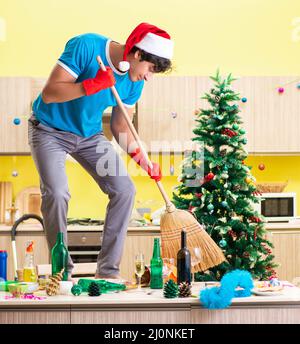 Giovane uomo cucina pulizia dopo la festa di Natale Foto Stock