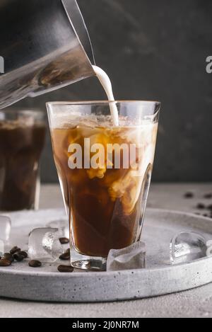 Versare il latte in un bicchiere con il caffè. Alta qualità e risoluzione bellissimo concetto di foto Foto Stock