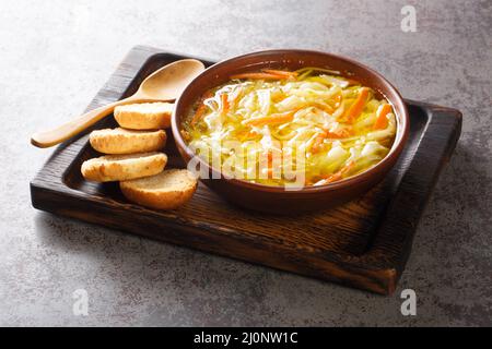 Zuppa di julienne vegetale con dieta sana servita con toast primo piano in una ciotola su un vassoio di legno orizzontale Foto Stock