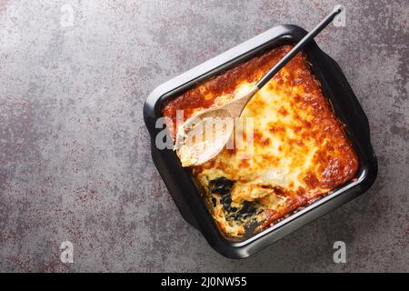 Casseruola portoghese Bacalhau espiritous delizioso merluzzo cotto con cipolla, carote grattugiate cosparse di formaggio grattugiato closeup nella teglia da forno. Hori Foto Stock