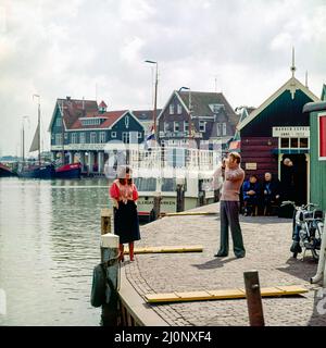 Vintage Netherlands 1970s, coppia di turisti di mezza età che scattano foto, porto di Marken, Waterland, Olanda settentrionale, Europa, Foto Stock