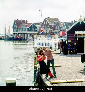Vintage Netherlands 1970s, coppia di turisti di mezza età che scattano foto, porto di Marken, Waterland, Olanda settentrionale, Europa, Foto Stock