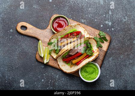 Piatto messicano fajita tacos su tagliere di legno dall'alto Foto Stock