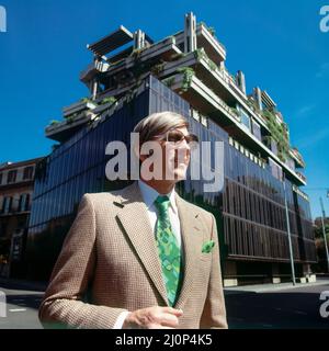 Vintage Rome 1970s, elegante ritratto uomo di mezza età con occhiali da sole di fronte ad un edificio moderno, Italia, Europa, Foto Stock