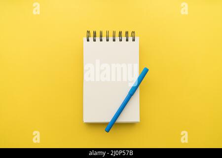 Blocco note con sfondo giallo a penna. Alta qualità e risoluzione bellissimo concetto di foto Foto Stock