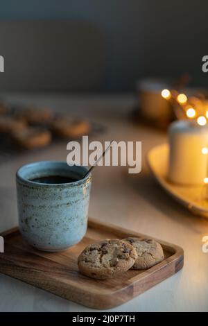 Sfondo natalizio con biscotti al cioccolato, tazza di tè. Serata accogliente, Foto Stock