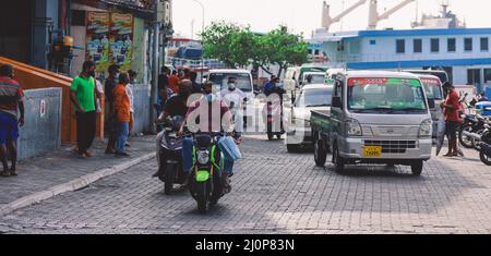 Maldivian gente locale che guida sulle bici sulle strade della città di Male Foto Stock