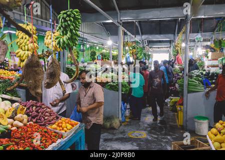 La gente del posto acquista frutta e verdura fresca e colorata sul mercato Maldiviano di Male City Foto Stock