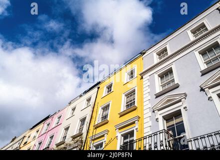 Case a schiera colorate con sfondo cielo estivo e spazio per il testo. La zona di Notting Hill, Londra, è famosa per le strade delle case con la Foto Stock