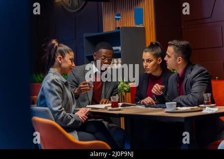 Gruppo di gente di busniess multirazziale sta avendo una conversazione circa l'azienda Foto Stock