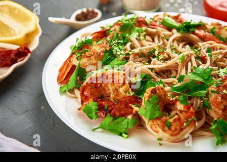 Friggere la noodle con gamberi e prezzemolo fresco sul piatto bianco, soba con gamberi, cucina asiatica Foto Stock