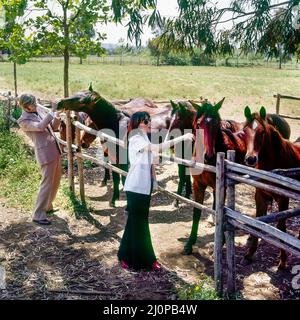 Vintage Italy 1970s, elegante coppia di mezza età visita allevamento di cavalli, ranch di campagna romana, Lazio, Europa, Foto Stock