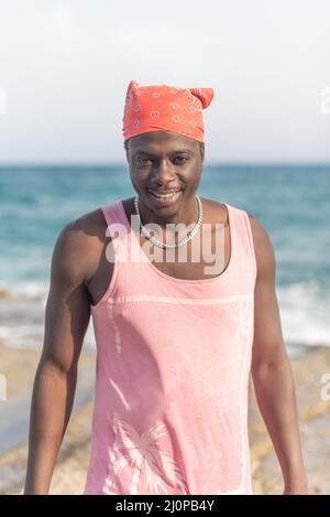 uomo in t-shirt rosa con spiaggia sullo sfondo Foto Stock