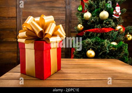 Regalo di Natale e Capodanno Red Box decorato da nastro d'oro e Big Golden Loopy Bow. Albero di Natale con palle, nastri, San Foto Stock