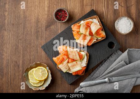 Smorrebrod - panini tradizionali danesi. Pane di segale nero con salmone, formaggio cremoso Foto Stock