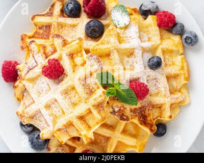 Waffle belgi con lamponi, mirtilli, cagliata e tè, vista dall'alto. Foto Stock