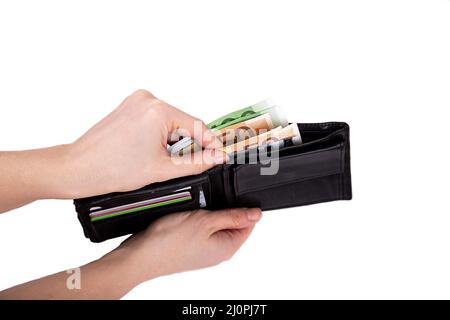 Un uomo sta tenendo un portafoglio aperto con soldi su uno sfondo bianco primo piano Foto Stock