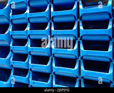 Scatole di plastica blu impilate in vendita in un negozio di hardware Foto Stock