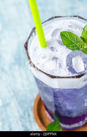 rinfrescante cocktail di cocco blu su sfondo di pietra blu Foto Stock