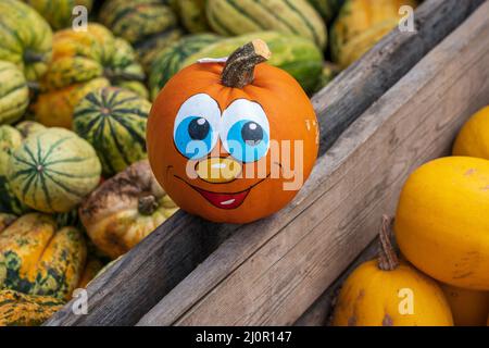 Faccia di zucca su una gabbia piena di zucche Foto Stock