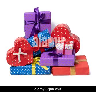 Pila di scatole avvolte in carta e legate con un nastro di seta su sfondo bianco, celebrazione. Set di confezioni regalo Foto Stock