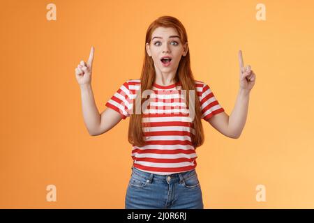 Sorpresa cute ragazza 20s lunghi capelli rossi belle orecchie, ispirato impressionante interessante conferenza che mostra voi copiare spazio promo, aperto mo Foto Stock