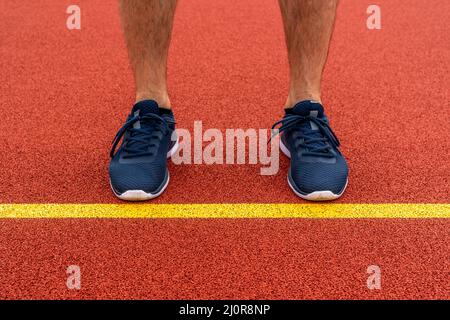 Uomo in piedi dietro la linea gialla nel terreno sportivo Foto Stock