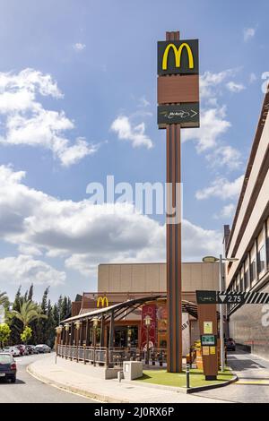 Huelva, Spagna - 19 marzo 2022: McDonald's McAuto Drive all'ingresso. McDonald's è una multinazionale americana di fast food, fondata nel 1940 come Foto Stock