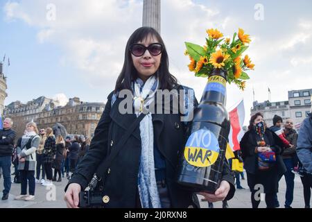 Londra, Inghilterra, Regno Unito. 20th Mar 2022. Una donna tiene una grande bottiglia con girasoli e un segno di No War'. La grande folla continua a riunirsi a Trafalgar Square a sostegno dell’Ucraina, mentre la Russia intensifica il suo attacco. (Credit Image: © Vuk Valcic/ZUMA Press Wire) Credit: ZUMA Press, Inc./Alamy Live News Foto Stock