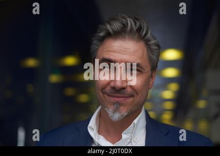 Ritratto di affari - felice uomo d'affari grigio haired più vecchio in ufficio di affari. Foto Stock