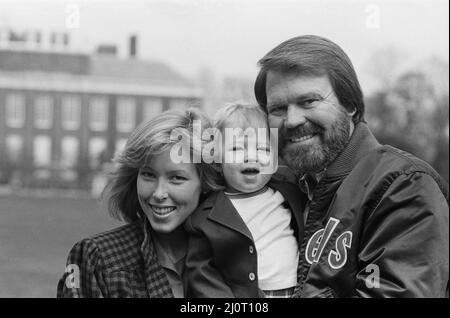 Glen Campbell e il suo Kim e un figlio di un anno Cal, a Londra. 19th aprile 1984 Campbell sposò Kimberly 'Kim' Woolen nel 1982. La coppia si è riunita in una data cieca nel 1981 quando Woolen era una radio City Music Hall 'Rockette'. Insieme, hanno tre figli: CAL, Shannon e Ashley. Tutti e tre si sono Uniti a Campbell sul palco dal 2010 come parte della sua band itinerante. I successi di Campbell includono le sue registrazioni di "Gentle on My Mind" di John Hartford; "by the Time i get to Phoenix" di Jimmy Webb, "Wichita Lineman" e "Galveston"; "Rhinestone Cowboy" di Larry Weiss; e "Southern Night" di Allen Toussaint Foto Stock