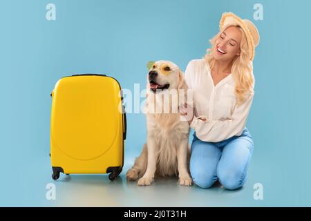 Donna felice in posa con il cane in occhiali da sole in vacanza Foto Stock