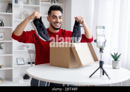 Video di unboxing. Arabo Male Blogger registrazione contenuto per il suo blog a casa Foto Stock
