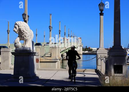 Il Leone di marmo mediceo custodisla il Ponte dei Leoni sulla Baia di Matanzas con la sagoma di un uomo sulla sua bicicletta.St.Augustine.Florida.USA Foto Stock