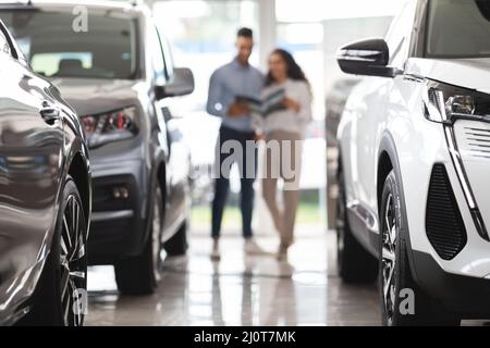 Donna che sceglie una nuova auto, che ha avuto una conversazione con il responsabile delle vendite Foto Stock