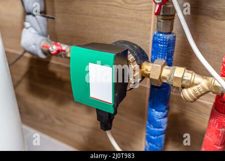 Pompa di circolazione per acqua calda in un moderno locale caldaia a gas rivestito di piastrelle in ceramica. Foto Stock