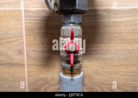 Aprire le valvole dell'acqua che si collegano alla caldaia a gas in un moderno locale di caldaie con piastrelle in ceramica. Foto Stock