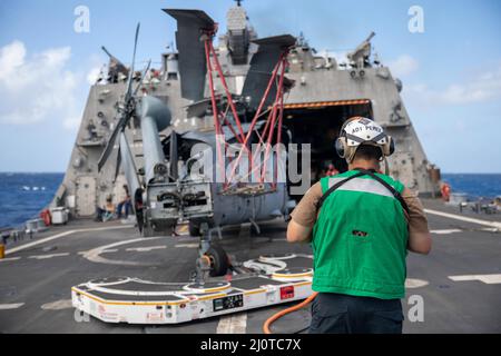 220122-N-GF955-1015 MAR DEI CARAIBI - (GEN. 22, 2021) -- Aviation Machinist Mate 1st Classe Ernesto Perez, assegnato al “Shadow Det” di Helicopter Sea Combat Squadron (HSC) 28, distaccamento 7, trasporta un elicottero MH-60s Sea Hawk al ponte di volo della nave da combattimento litoranea variante libera USS Billings (LCS 15), 22 gennaio 2022. Billings è dispiegato nell'area delle operazioni della flotta USA 4th per sostenere la missione della Joint Interagency Task Force South, che include missioni di lotta contro il traffico illecito di droga nei Caraibi e nell'Est del Pacifico. (STATI UNITI Foto Navy di Mass Communication Specialist 3R Foto Stock