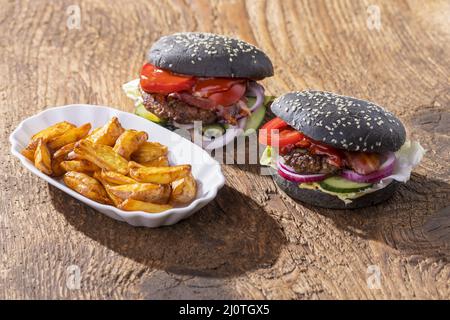Primo piano degli hamburger neri su legno Foto Stock