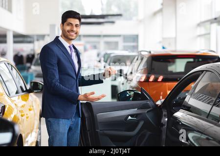 Allegro direttore delle vendite medio-orientali mostrando una bella auto Foto Stock