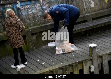 Copenhagen/Denmark/.19 .March 2022/uso volontario della famiglia domenica vacanza per pict up rifiuti a turisti e attrazioni locali il famoso canale christianshavn per mantenere il canale pulito a Copenhagen. (Foto..Francis Dean/Dean Pictures) Foto Stock