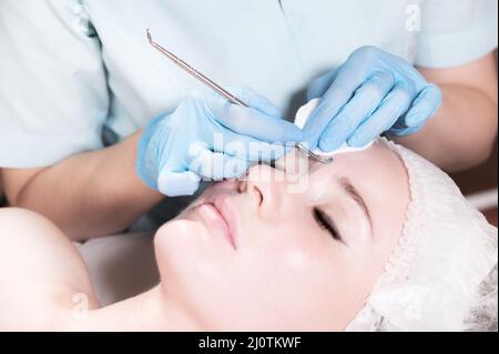 Rilassato giovane donna caucasica ad un appuntamento estetista. Pulizia meccanica del viso e peeling. Primo piano Foto Stock