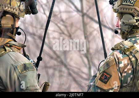 Il personale militare delle forze Armate nazionali lettoni lavora fianco a fianco con i soldati dell'esercito statunitense assegnati a Battery C, Battaglione 1st, reggimento dell'artiglieria da campo 120th, Guardia Nazionale dell'Esercito del Wisconsin, mentre conduce una stretta formazione di supporto aereo durante lo Sciopero settentrionale 22-1 ("Sciopero invernale") presso il National All-Domain Warfighting Center, Grayling, Michigan, gennaio 27, 2022. “Winter Strike”, l’iterazione invernale del programma di esercizi dello sciopero settentrionale, si svolge presso il National All-Domain Warwfighting Center del Michigan settentrionale. Il NADWC è il luogo perfetto per le unità del reparto DEF Foto Stock