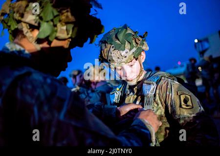 Bizerte, Tunisia. 3rd Mar 2022. Un paracadutista dell'esercito degli Stati Uniti assegnato a 1st Squadron, 91st Cavalry Regiment (Airborne) ottiene il suo paracadute rigged in su durante un'operazione di trasporto aereo insieme ai soldati dal gruppo speciale tunisino delle forze vicino a Bizerte, Tunisia il 3 marzo 2022. La Brigata aerea del 173rd è la forza di risposta di contingenza dell'esercito degli Stati Uniti in Europa, che fornisce forze rapidamente dispiegabili alle aree di responsabilità europee, africane e del comando centrale degli Stati Uniti. Forward schierata in Italia e Germania, la brigata si forma regolarmente insieme agli alleati e ai partner della NATO per costruire partnership AN Foto Stock